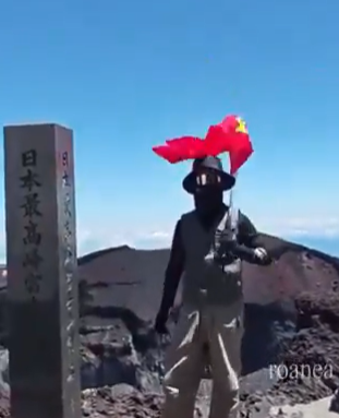 富士山頂で国旗を掲げる中国人
