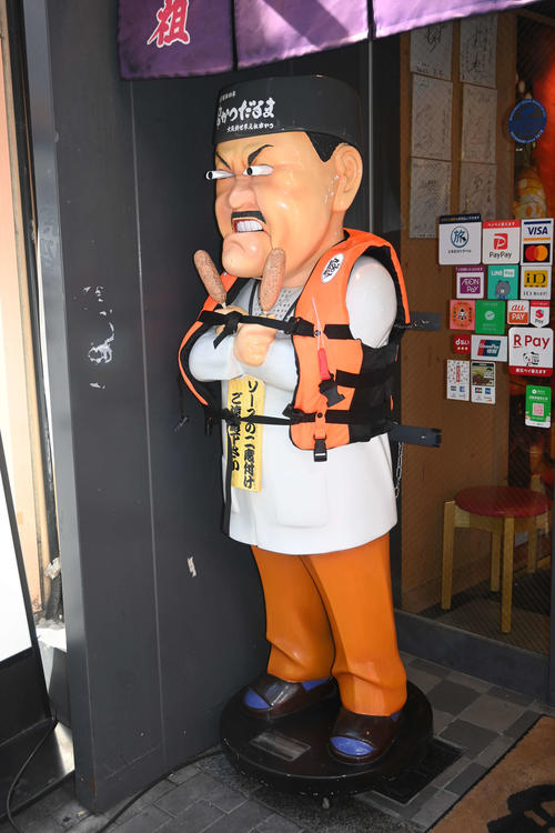 【阪神優勝目前】戎橋近くの串かつだるま道頓堀店・名物人形が救命胴衣を着用・・・店長 「もしものとき、浮き上がってもらえるようにという思いを込めて、救命胴衣をつけさせていただいた」