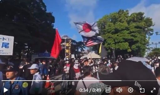 日本国旗とアメリカ国旗にバツ印をつけて反政府デモを行う集団が登場！